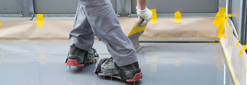 Person trägt Beschichtung auf Boden auf